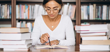 Empresária lendo livros sobre planejamento estratégico