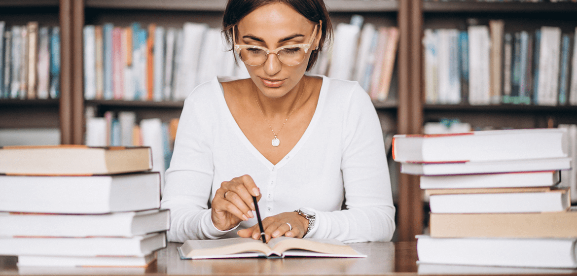 Empresária lendo livros sobre planejamento estratégico