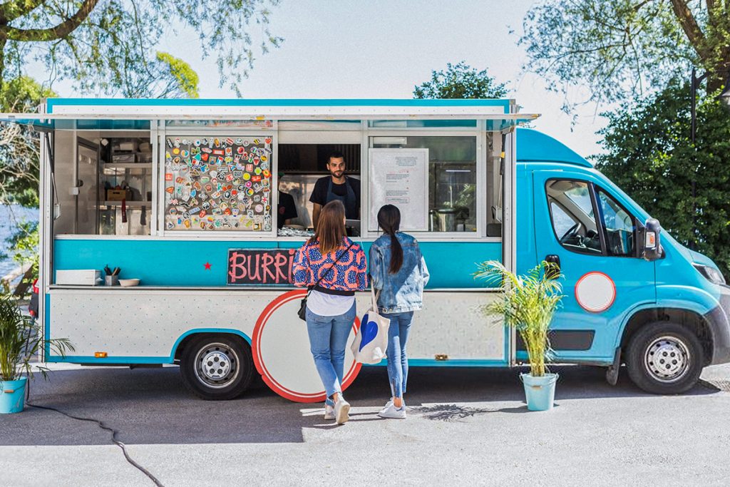 duas mulheres comprando burritos em um food truck